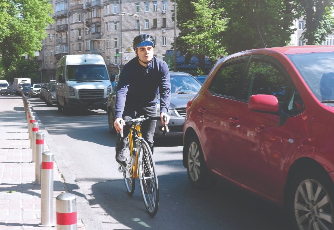cyclist riding next to the curb, trying to avoid a right hook collision