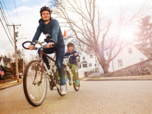 parent and child riding bikes together on a residential street